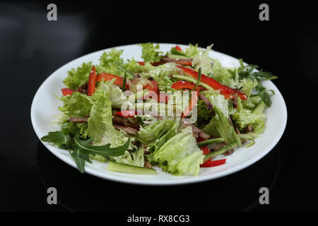Ristorante dish, verde con insalata di cetrioli, pepe rosso, pancetta e rucola, cibo sano, close-up, per il menu Foto Stock