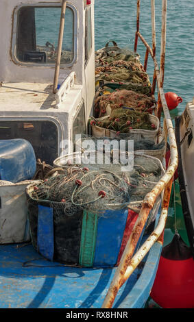 I contenitori pieni di Fisherman's reti. Le reti sono allineate sul ponte della barca da pesca. Ritratto di metà della barca. Foto Stock