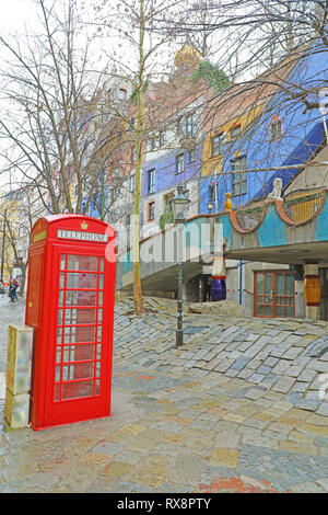 VIENNA, Austria - 9 gennaio 2019: Rosso phone booth in Vienna street con Hundertwasserhaus Foto Stock