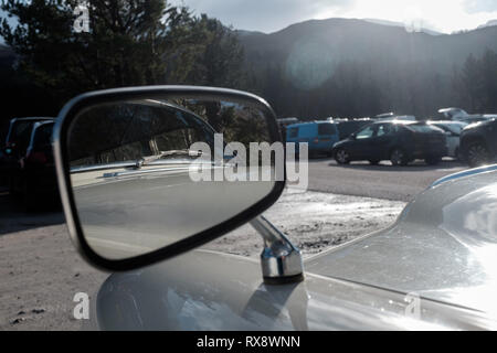 Guardando alla riflessione in un classico Volvo Station wagon specchietto laterale parcheggiato in nevis gamma parcheggio auto highlands scozzesi Scotland Regno Unito Foto Stock