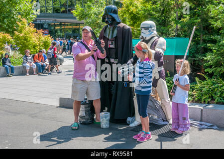 Una famiglia avente la loro fotografia scattata con Star Wars personaggi di Darth Vader & Imperial Stormtrooper costumi presso il centro di Seattle. Foto Stock