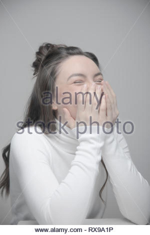Ritratto giocoso bella giovane donna ridere con testa in mani