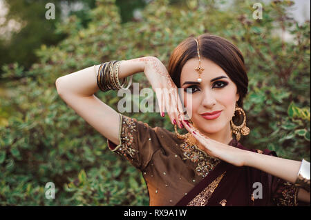 Mehendi sulle mani di ragazze, Donna mani con brown mehndi tattoo. Le mani della sposa indiano ragazza con brown Henna Tattoos. Foto Stock