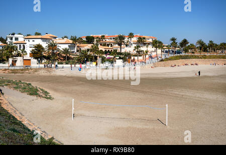 Torrevieja, Spagna - 19 Febbraio 2019: sabbiosa Playa Flamenco beach in inverno i turisti viaggiatori godere di febbraio mese giacente in lettini abbronzanti caldo caldo Foto Stock