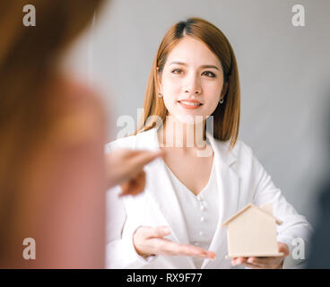 Home vendita rappresentante presente buona casa e cliente calcolare circa il prestito ipotecario finanziari per prendere la decisione di vendere casa, agente di assicurazione analyzi Foto Stock