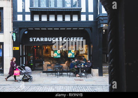 CHESTER, Inghilterra - 8 MARZO 2019: uno Starbucks nel mezzo di Chester conun gruppo di amici gustando un caffè al di fuori Foto Stock