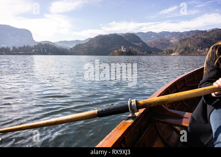 Giovane donna con paletta su una barca di legno - Lago di Bled Slovenia il canottaggio su barche in legno Foto Stock