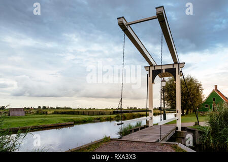 Passerella sul canal dal paesaggio contro il cielo nuvoloso durante il tramonto Foto Stock