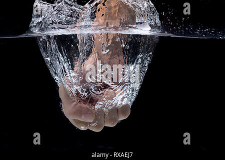 Un concetto foto di un pugno punzonatura in acqua in una impostazione di studio. Foto Stock