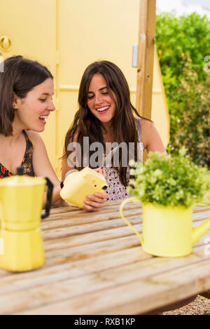 Happy amici di sesso femminile guardando stampa istantanea trasferimento al cortile Foto Stock