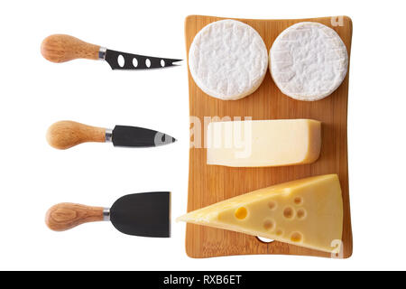 I diversi tipi di formaggi - brie, camembert, parmigiano e gouda sulla tavola di legno con coltelli da formaggio isolato su bianco Foto Stock