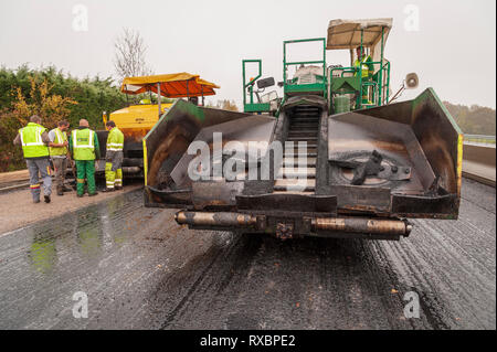 Il trasferimento del materiale veicolo utilizzato per assistere il lastricatore accettando di asfalto. Collegamento tra carrello e cemento. vista frontale. Foto Stock