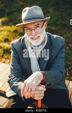 Elegante uomo vecchio in un soleggiato parco di autunno Foto Stock