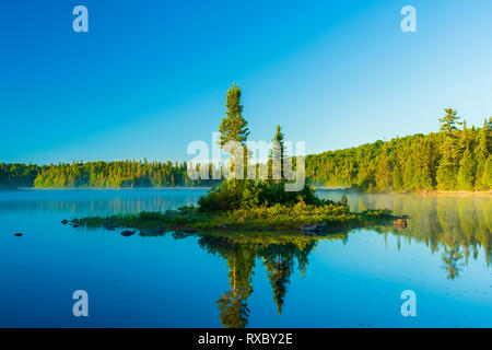 Isola nel lago Mijinemungshing mattina presto, Lago Superior parco provinciale, Ontario, Canada Foto Stock