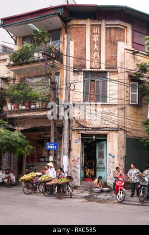 Vietnamita locale sul ciglio della strada con le biciclette che porta frutti di attesa per i clienti, Hanoi, Vietnam Foto Stock