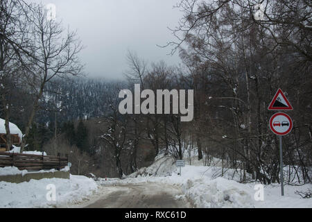 Strada di inverno in montagna in inverno in scena con la neve, alberi, winter resort Smolyan, Bulgaria, Monti Rodopi. Strada in valle di montagna, favola invernale Foto Stock