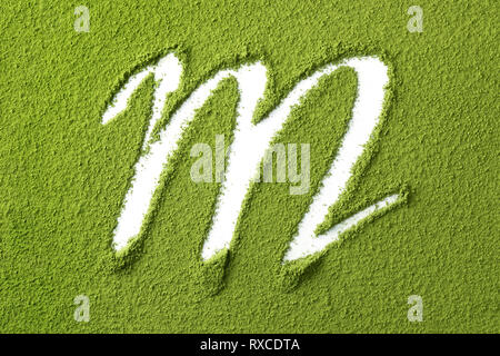 Giapponese verde Matcha Polvere di tè full frame e la lettera M close up Foto Stock