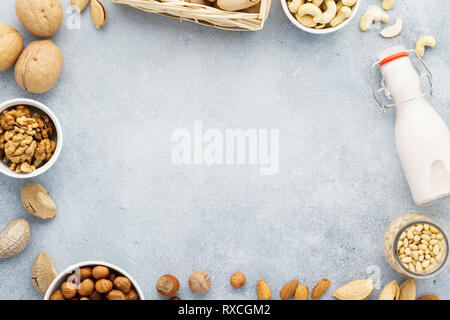 Senza latte e derivati sostituto del latte in una bottiglia e gli ingredienti. Varie materie i dadi. Vista dall'alto. Spazio per il testo. Foto Stock