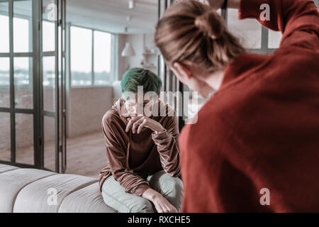 Biondo e sollevamento man mano sul suo inerme giovane moglie Foto Stock