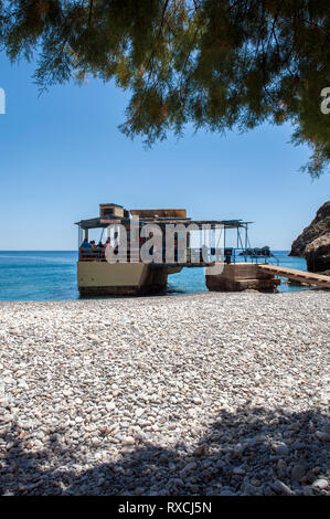 Una taverna costruita su rocce nel mare a Sweetwater Beach, tra Hora Sfakion e Loutro sulla costa meridionale di Creta Foto Stock