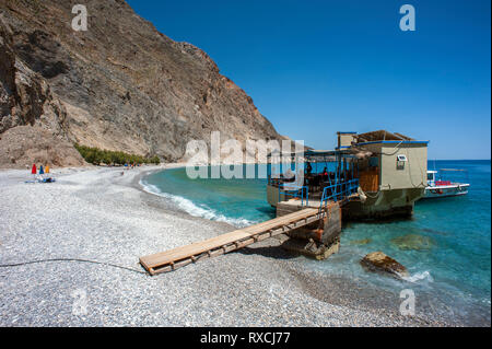 Una taverna costruita su rocce nel mare a Sweetwater Beach, tra Hora Sfakion e Loutro sulla costa meridionale di Creta Foto Stock