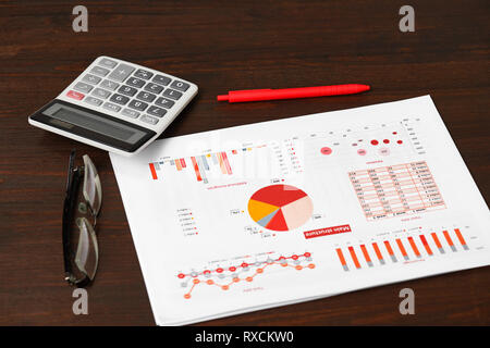 Red report, grafici e calcolatrice per il calcolo delle finanze sul desk office. Azienda di contabilità finanziaria concetto. Foto Stock