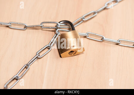 Serratura a chiave bloccata con una catena sulla tavola Foto Stock