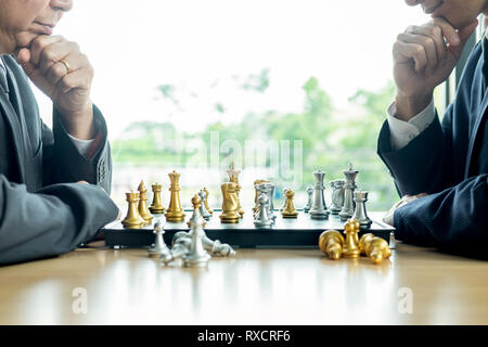 Imprenditore giocando a scacchi gioco di figure sul tavolo di legno per analisi nuovo piano strategico, concorrenza leader e il concetto di lavoro di squadra per il successo. Foto Stock