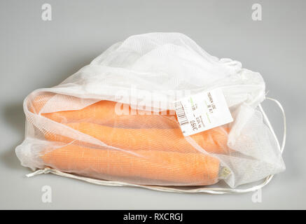 Confezionamento Alimentare, carote in una plastica riutilizzabile net, evasione di rifiuti di plastica, Foto Stock