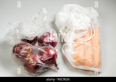 Confezionamento Alimentare, carote in una plastica riutilizzabile net, evitando di immondizia di plastica, cipolle del tipo usa e getta il sacchetto in plastica, Foto Stock