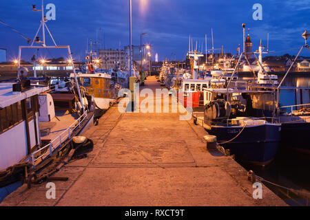 Barche da pesca ormeggiate ad un grande molo di cemento di notte nel porto della città Wladyslawowo in Polonia Foto Stock