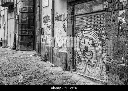 Napoli, Italia - 08 Agosto 2015 : strette strade di Napoli, le fotografie in bianco e nero. Vista su i graffiti sulla porta del garage. Foto Stock