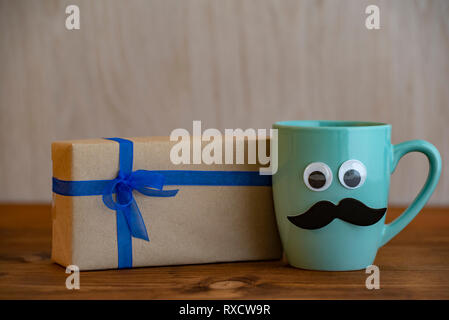 Felice giorno padri concetto con tazza di caffè, baffi e confezione regalo su sfondo di legno Foto Stock