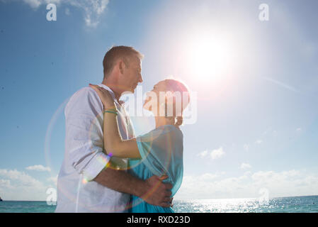 Ritratto di giovane, cercando ogni altro romanticamente. Il mare è dietro di loro. Immagine della retroilluminazione. Colori caldi. Lens Flare presso l'immagine Foto Stock