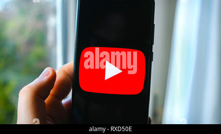 Mano app YouTube smartphone di simbolo Foto Stock