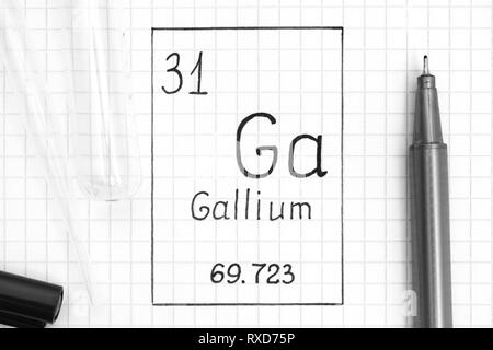 Tavola periodica degli elementi. La grafia elemento chimico Gallio Ga con la penna nera, tubo di prova e la pipetta. Close-up. Foto Stock