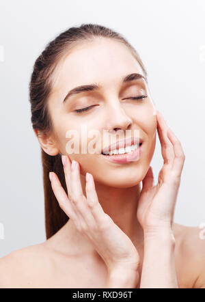 Ritratto di Pretty girl mettendo la crema sul suo viso Foto Stock