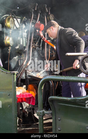 Kidderminster, Regno Unito. 9 Marzo, 2019. Nonostante la soleggiata incantesimi, si tratta di un freddo e ventilato in marzo mattina nelle Midlands. Una sorta-hearted Steam Railway macchinista sorge sulla pedana per la cottura fino hot salsicce e pancetta baps per il suo equipaggio in questa annata del motore del focolare. Come l'equipaggio capi per il giorno, in piedi la locomotiva aperto cabina, la loro colazione calda baps aiuterà certamente tenere fuori il freddo vento che sarà rivolta verso l. Credito: Lee Hudson/Alamy Live News Foto Stock