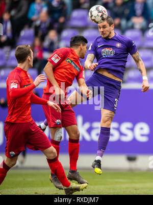 Aue, Germania. 09Mar, 2019. Calcio: Seconda Bundesliga, Erzgebirge Aue - SC Paderborn 07, XXV Giornata nel Sparkassen-Erzgebirgsstadion. Aues Pascal Testroet (r) contro Paderborn's Mohamed Dräger (M) e Sebastian Schonlau. Credito: Robert Michael/dpa-Zentralbild/dpa - NOTA IMPORTANTE: In conformità con i requisiti del DFL Deutsche Fußball Liga o la DFB Deutscher Fußball-Bund, è vietato utilizzare o hanno utilizzato fotografie scattate allo stadio e/o la partita in forma di sequenza di immagini e/o video-come sequenze di foto. Credito: dpa picture alliance/Alamy Live News Foto Stock