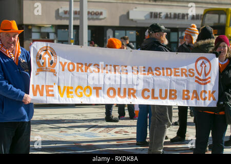 Blackpool, Lancashire, Regno Unito. 9 Marzo, 2019. I sostenitori di Blackpool si raccolgono sul lungomare prima della partita in casa a Bloomfield Road per celebrare la destituzione di Owen Oyston dal club di calcio. Blackpool FC lungo sofferenza appassionati hanno finalmente un loro club back & stanno ritornando a vedere il loro gioco di squadra. Il giorno è finalmente giunta per Blackpool di boicottare le ventole per tornare a casa e sostenere il loro team. Credito: MediaWorldImages/AlamyLiveNews Foto Stock