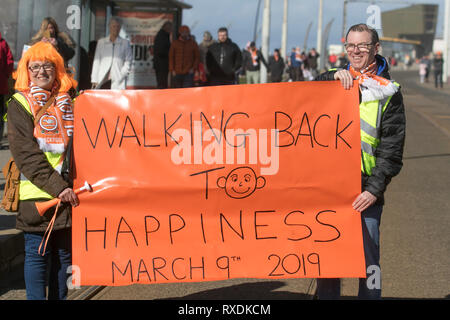 Blackpool, Lancashire, Regno Unito. 9 Marzo, 2019. I sostenitori di Blackpool si raccolgono sul lungomare prima della partita in casa a Bloomfield Road per celebrare la destituzione di Owen Oyston dal club di calcio. Blackpool FC lungo sofferenza appassionati hanno finalmente un loro club back & stanno ritornando a vedere il loro gioco di squadra. Il giorno è finalmente giunta per Blackpool di boicottare le ventole per tornare a casa e sostenere il loro team. Credito: MediaWorldImages/AlamyLiveNews Foto Stock