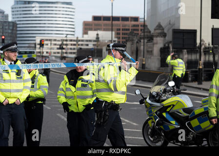 Paura bomba. Un'auto sospetta parcheggiata al di fuori del quartier generale della polizia di New Scotland Yard a Victoria Embankment, Westminster, Londra, Regno Unito ha causato la polizia a bloccare e liberare l'area circostante, le strade locali e il ponte di Westminster, tra cui l'arresto del traffico fluviale sul Tamigi. La polizia ha rotto lo schermo posteriore della vettura per entrare. La polizia si è adunata e si è liberata di Westminster Bridge Road Foto Stock