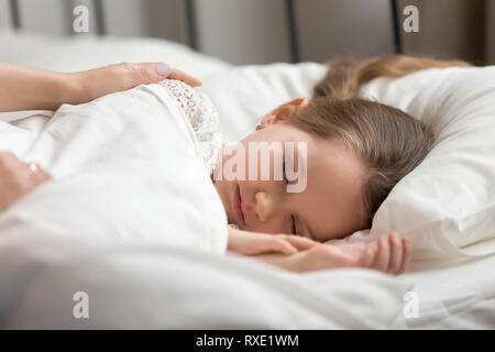 Mom mani toccano sleeping kid figlia svegliarsi bambino Foto Stock