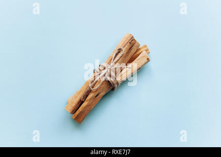 Un set di bastoni di legno Palo Santo su uno sfondo blu. Essi sono utilizzati in aromaterapia e riti religiosi e meditazioni. Foto Stock