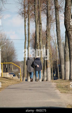 Coppia di giovani a piedi sul vicolo in city park abbraccio Foto Stock