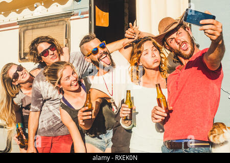 Gruppo di crazy giovani uomini caucasici di uomini e donne che assumono selfie foto facendo divertenti - espressioni di amicizia e di concetto giovanile - vecchia roulotte in Foto Stock