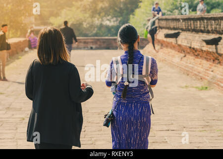 Backview femminile di turisti alla antica Pa Hto Taw Gyi Pagoda rovine a Mingun città vicino a Mandalay, Myanmar. Foto Stock