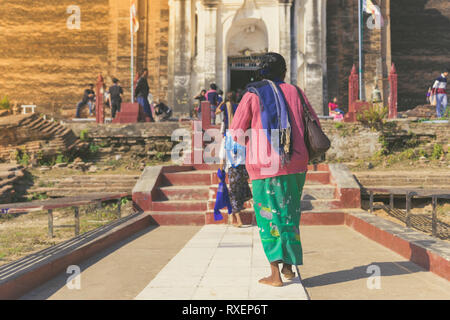 Backview del turista femminile all'antica Pa Hto Taw Gyi Pagoda rovine a Mingun città vicino a Mandalay, Myanmar. Foto Stock