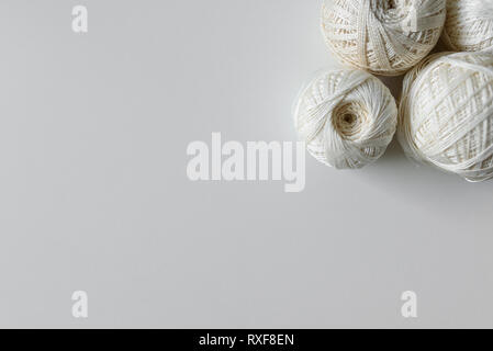 Vista dall'alto sulla matassa di fili di cotone per l'artigianato in colore beige, su sfondo bianco con copia spazio. Foto Stock