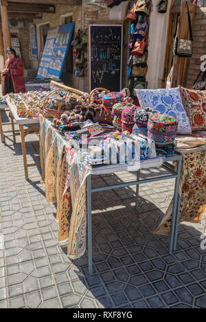 BUKHARA, UZBEKISTAN - Ottobre 19, 2016: commercio di souvenir sulla strada a Bukhara. Skullcaps ricamato, borse, cuscini, tovaglie e altri souvenir Foto Stock